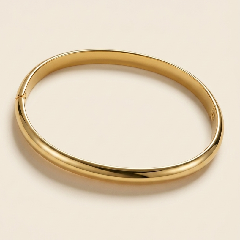Bracelet jonc rigide en or poli brillant sur fond crème minimaliste - Collection Palmyra Jewels